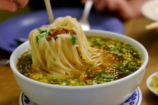 Mì người Shan: Sợi mì dẹt và mảnh được chan nước dùng cay, cho thêm thịt lợn hoặc thịt gà, vừng rang và chút dầu tỏi. Món này được ăn cùng rau củ muối. Ảnh: Flavorverse.
