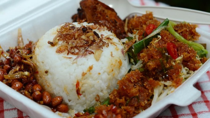 Nasi uduk là món ăn truyền thống được người dân địa phương yêu thích và lựa chọn cho bữa trưa. Cơm được nấu với nước cốt dừa, xung quanh là thịt, lạc rang, rau xào, cá cơm. Địa chỉ: Nasi Uduk Babe Saman, số 3, đường Kebon Kacang, thủ đô Jakarta. Quán ăn nằm gần chợ Gandaria Los Kolontong.