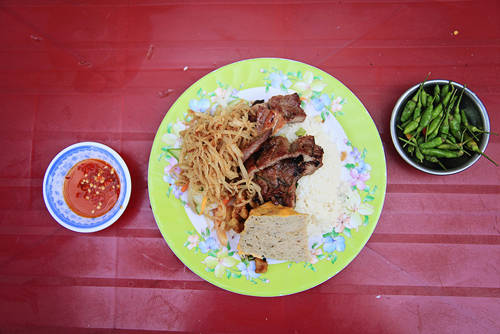 Cơm tấm sườn bì chả Ngày xưa, cơm tấm là món ăn sáng được chuộng nhất của người dân mọi tầng lớp ở Sài Gòn. Thời nay, món ăn có thể dùng mọi lúc trong ngày từ sáng sớm đến tối mịt. Tuy nó có thể xuất hiện trong những nhà hàng máy lạnh nhưng đối với nhiều người, để thưởng thức món ăn này một cách “đúng điệu Sài Gòn” phải ở một góc đường hay một con hẻm nào đó, với mùi sườn nướng tỏa trong làn khói mờ ảo. Miếng thịt nướng dậy mùi thơm phức ăn chung với miếng chả mềm, sợi bì dai dai, quyện cùng vị mắm mặn vừa phải. Những ai từng ăn qua món ăn này khó lòng mà quên được. Ảnh: Phong Vinh