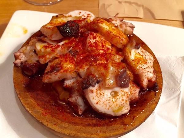 Pulpo a la gallega là món bạch tuộc luộc rồi gia giảm với muối, tiêu ngọt và phục vụ khách bằng đĩa gỗ. Ảnh: Insider.