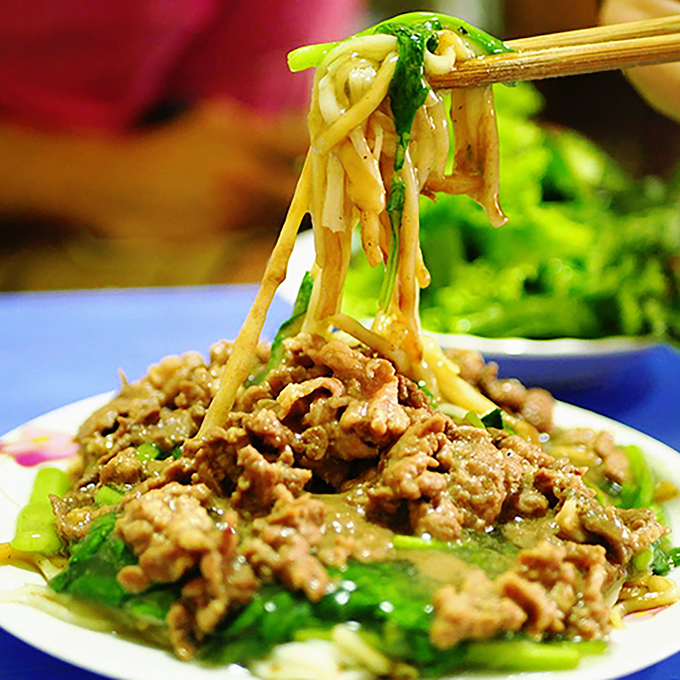 Phở xào  Món ăn được bưng ra với thứ nước sốt đặc sệt phủ lên thịt bò, rau cải và những sợi phở nóng hổi. Trước khi ăn, bạn có thể thêm một chút xì dầu, tương ớt để món ăn trở nên đậm đà hơn, rất thích hợp cho những người tìm kiếm một món ăn nhanh, nóng và đủ chất trong ngày trời lạnh. Món phở xào còn có một biến tấu khác ở cửa hàng trên phố Hàng Buồm với sợi phở xào khô, săn lại, đôi khi có chỗ cháy cạnh thơm phức.  Gợi ý địa chỉ: 45B Bát Đàn, 11 Hàng Buồm, dãy nhà hàng phở ngã tư Nguyễn Khắc Hiếu - Ngũ Xã. Giá: 50.000 - 60.000 đồng một đĩa. Ảnh: Di Vỹ.
