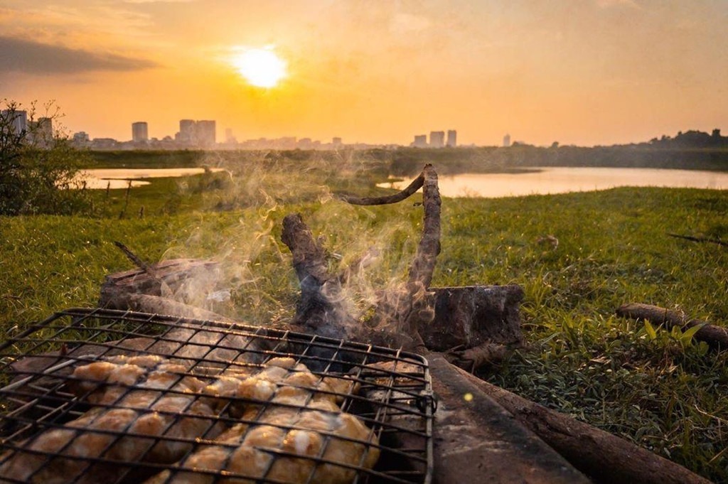 Bãi bồi chân cầu Vĩnh Tuy cách trung tâm Hà Nội hơn 30 phút đi xe, dưới đây tồn tại thế giới hoàn toàn đối lập với sự nhộn nhịp của phố thị Hà thành. Chốn sống ảo này sở hữu nhiều khu đất trống hàng cỏ xanh mượt mà, là địa điểm lý tưởng cho những ai muốn xa rời chốn ồn ào, ngột ngạt khói bụi. Bạn cần tìm bãi đất bằng phẳng, dải thêm tấm thảm êm rồi cứ thế tận hưởng cảnh hoàng hôn trong không gian cực "chill". Ảnh: Lana.photo_.