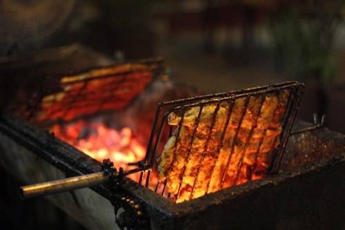 Vịt được kẹp vào vỉ nướng dưới than hoa cho đến khi chín đều, thơm nức mùi gừng, sả. Ảnh: Út Liên.