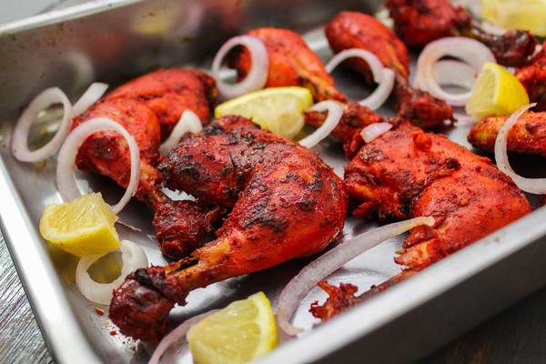 Gà Tandoori - Đặc sản thế giới: Có xuất xứ ở vùng Punjab từ thời Mughal, món gà Tandoori được làm từ thịt gà ướp hỗn hợp sữa chua và gia vị, sau đó nấu trong nồi đất. Người nấu thường cho thêm nghệ để món ăn có màu cam, hoặc ớt bột để có màu đỏ hấp dẫn. Ảnh: Earthindian.