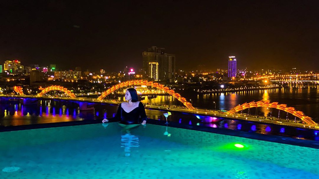 Du khách Thảo Anh (Hải Phòng) nhận xét hồ vô cực ở khách sạn Val Soleil đẹp nhất vào buổi tối. Lúc này, Đà Nẵng lên đèn ảo diệu, cầu Rồng vàng rực bắc qua sông Hàn, tạo background chụp hình cực chất cho các tín đồ sống ảo. Vừa nhìn cầu Rồng phun lửa, vừa thư giãn dưới làn nước mát trong bể vô cực là trải nghiệm bạn nên thử khi ghé Đà Nẵng. Ảnh: pim_ba.