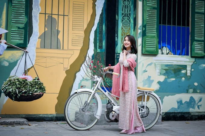 Chụp ảnh với chậu hoa đào tại phố bích họa Phùng Hưng