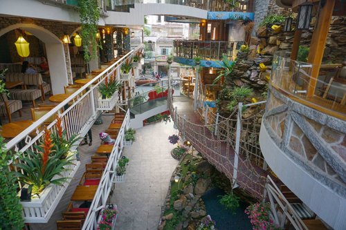 Café City Garden  Đến quán cà phê ở quận Tân Bình, bạn sẽ có cảm giác như bị lạc vào một vườn cổ tích bí ẩn. Nơi đây có thác nước khá lớn, tạo không gian mát mẻ cho thực khách. Thực đơn khá đa dạng, bạn có thể lựa chọn các loại thức uống như: cappuccino, sinh tố dâu, peach tea mania, mojito lemon hoặc các món ăn nhẹ như bò lúc lắc, bánh mì, cơm thịt kho trứng vịt.