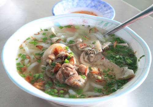Bánh canh giò heo Tô bánh canh bột lọc với miếng giò heo, đĩa rau sống, đơn giản vậy mà hầu như ai đi Vũng Tàu cũng đều ăn thử. Sợi bánh canh ở đây được chế biến hoàn toàn bằng bột lọc nên thường có màu trắng đục, mềm nhưng dai và không bị bở hoặc gãy nát. Nước dùng được ninh từ cá biển, tôm và xương ống. Có vài lựa chọn như bánh canh thịt nạc, tôm thịt… nhưng bánh canh giò heo được nhiều người yêu thích nhất. Thực khách có thể chọn giò gân hoặc giò nạc. Quán nổi tiếng nhất là bánh canh Long Hương ở cổng chào Bà Rịa (trên đường đi Vũng Tàu), giá 45.000 đồng một tô; hoặc bạn có thể ghé các quán ở chợ Vũng Tàu. Ảnh: Huấn Phan.