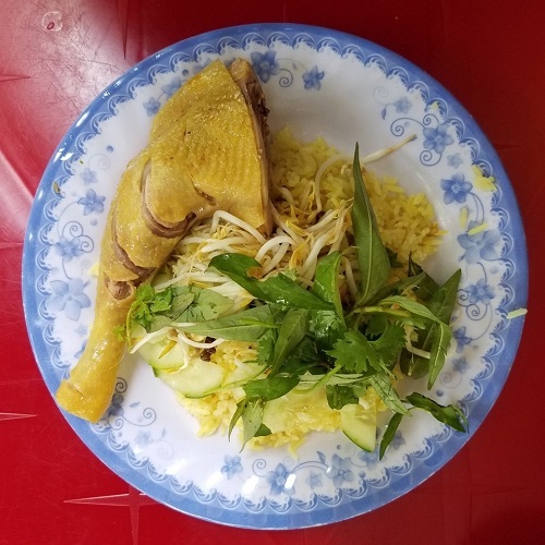 Cơm gà Phú Yên với phần đùi gà chín vàng được xếp cùng rau dăm, giá, hành củ muối khi du lịch Phú Yên. Ảnh: Tung Nguyen.