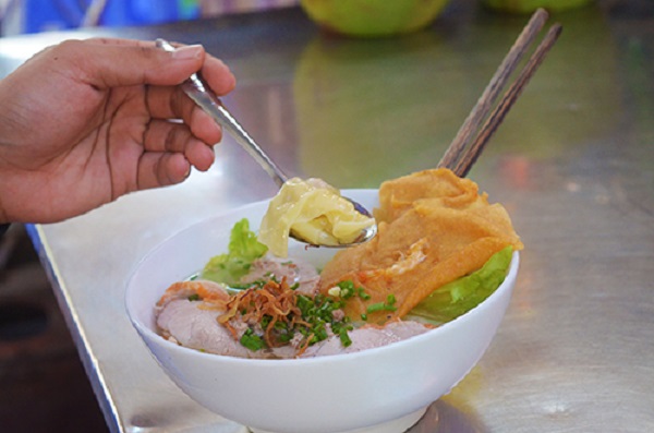Hoành thánh Món hoành thánh của người Hoa được biến tấu thành súp, chiên hoặc ăn kèm với mì. Quán nằm bên hông chợ, nổi tiếng với vị nước lèo ngọt thanh, miếng hoành thánh mềm. Tô hoành thánh còn có vài lát thịt heo, bánh tôm chiên giòn. Khi ăn, khách có thể nêm thêm chút chanh hoặc ớt để tăng thêm hương vị. Giá trung bình cho một phần là 30.000 đồng. Ảnh: Phong Vinh.