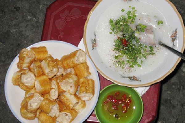 Cháo sườn Gần khu vực chợ có tới hàng chục xe cháo sườn, nhưng ngon nhất là hàng cháo vỉa hè nằm đối diện khu chợ. Hàng này thường đông khách vào giờ tan tầm đến đêm muộn. Món đơn giản, dễ ăn, hấp dẫn khách bởi màu sắc, độ nóng hổi và vị ngon của miếng sườn. Tô cháo bưng ra lúc nào cũng còn khói, bên trên là chút tiêu và hành mùi tạo nên mùi thơm quyến rũ trong những ngày mưa ở Sài Gòn. Giá dao động 15.000 - 25.000 đồng, tùy theo yêu cầu của khách. Ảnh: Huấn Phan.