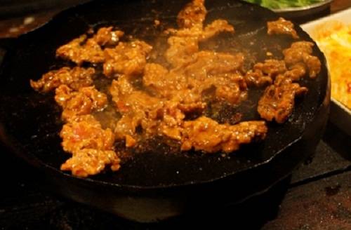 Bò nướng sặc Tên "bò nướng sặc" là cách gọi vui của thực khách. Bò được tẩm nhiều bột ớt cùng vài loại gia vị cho đậm đà. Khi nướng, hơi khói bốc lên cao khiến những người quanh đó đều ho sặc sụa. Khi ăn, bạn cuốn bò vào trong lá xà lách và chấm với nước sốt. Giá một bữa cho 3 người ăn khoảng 250.000 đồng. Bạn có thể ghé các quán nướng trên đường Bùi Thị Xuân. Ảnh: Pé Heo/ Ione.