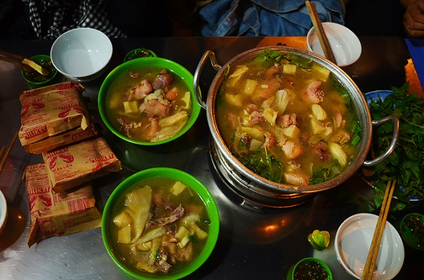 Thịt gà ăn kèm măng tươi, kẹp vài cọng lá é rồi chấm vào chén muối tiêu chanh cho đậm đà. Húp thêm một muỗng nước lẩu nóng hổi, bạn sẽ cảm nhận được vị ngọt bùi, cay nồng hòa quyện vào nhau. Một phần lẩu giá 200.000 đồng bao gồm nửa con gà chặt sẵn, một đĩa bún tươi, một đĩa nấm, một đĩa rau lá é.