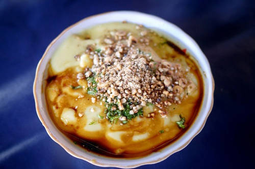 Hto-hpu nwe (bánh canh đậu hũ): Món ăn được chế biến từ một loại đậu được trồng ở Myanmar, nấu thành cháo, phủ một lớp bột màu vàng lên trên, cùng với rau thơm và ớt bột. Du khách có thể ăn kèm thêm thịt gà hay thịt lợn. Ảnh: Asiatrade.