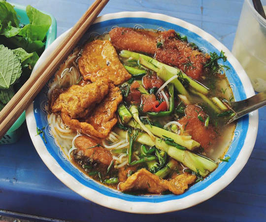 Bún cá Hàng Đậu là một trong những quán ăn đêm đáng chú ý. Một bát bún cá có nhiều chả cá, thịt cá được tẩm ướp rán giòn rụm. Nước sốt có sa tế khá cay và nóng được ăn kèm với rau sống, chút nộm hoa chuối thanh mát cùng ly trà đá tạo thành sự kết hợp hoàn hảo. Một bát bún cá giá 30.000 đồng. Ảnh: Khánh Ngọc.