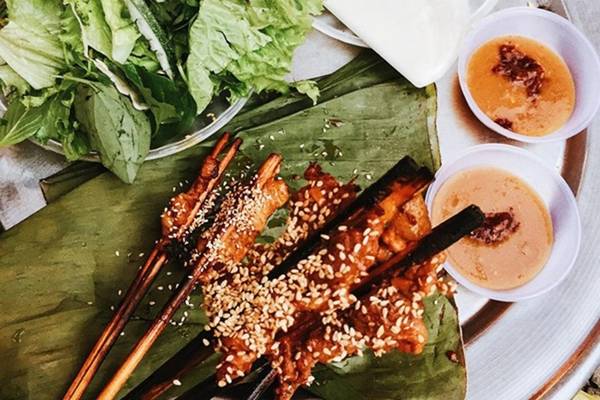 Thịt xiên nướng Từ phố Trần Phú cho đến góc đường Lê Lợi, Trần Hưng Đạo, Bạch Đằng, du khách dễ dàng bắt gặp hàng thịt nướng thơm phức. Thịt nướng trên bếp than hoa đang còn nóng hổi được cuốn trong một lớp bánh tráng mỏng, bánh ướt, rau thơm, khế chua, dưa chuột và chấm với nước sốt chế biến đặc biệt. Giá một xiên là 5.000 đồng. Ảnh: Lan Hương.