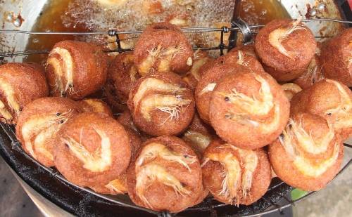 Bánh cống: Tới Sóc Trăng, du khách dễ gặp những xe bán bánh cống vàng rộm ở dọc đường hay trong các khu chợ. Lý giải tên gọi bánh cống, khuôn làm bánh bằng nhôm hình tròn, trên có tay cầm để khi đổ bánh dễ dàng cho việc vớt, người Sóc Trăng gọi là cống. Bánh cống ngon nhất là ở chính nơi được cho là nguồn gốc của nó - ngã ba đường vào chợ Đại Tâm, huyện Mỹ Xuyên (cách TP Sóc Trăng khoảng 8 km). Mỗi chiếc bánh cống có giá 8.000 đồng, ăn kèm rau sống và nước mắm chua ngọt, tạo nên vị đậm đà giòn rụm cùng vị thanh mát của rau. Ảnh: Ngọc Quí.