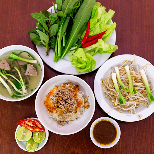 Phở khô Gia Lai  Sợi phở khô nhỏ như hủ tiếu, săn và hơi dai. Món ăn thường được phục vụ hai tô: một tô đựng bánh phở kèm thịt băm và một tô nước lèo trong, vị thanh ngọt. Đầu bếp thường hầm xương lợn và bò để ra nước có vị đậm đà này. Khách có thể lựa chọn đồ ăn kèm là thịt gà, bò hoặc bò viên. Mỗi suất ăn dao động từ 30.000 đồng. Các nhà hàng thường phục vụ thêm rau, giá.  Địa chỉ gợi ý: Quán phở khô Hồng là địa chỉ bạn không thể bỏ qua. Ảnh: Mr True.