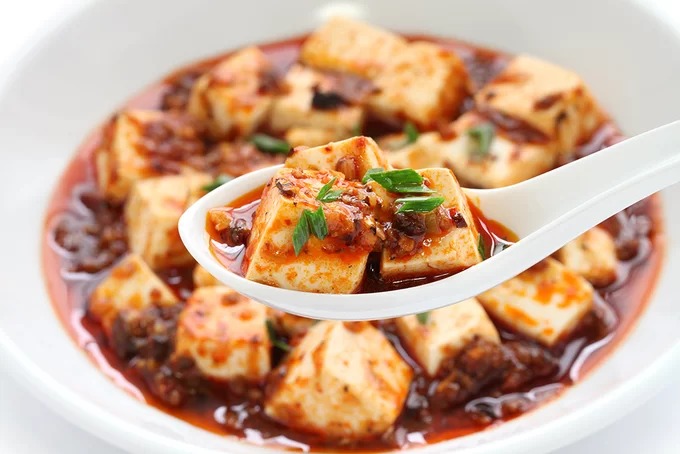 Đậu sốt Tứ Xuyên  Món ăn đặc trưng hương vị Tứ Xuyên cay và thơm nồng là lựa chọn cho những ngày đông lạnh giá. Tên gọi khác của nó là Đậu hũ Ma Bà, được đặt theo tên người phụ nữ đã sáng tạo nên món ăn thơm ngon này, Trần Ma Bà. Thông thường đậu hũ được nấu cùng thịt xay, nhưng nếu bạn muốn ăn chay thì có thể bỏ thịt đi, cũng vẫn tạo nên hương vị đặc biệt. Ảnh: Shutterstock/Bonchan.