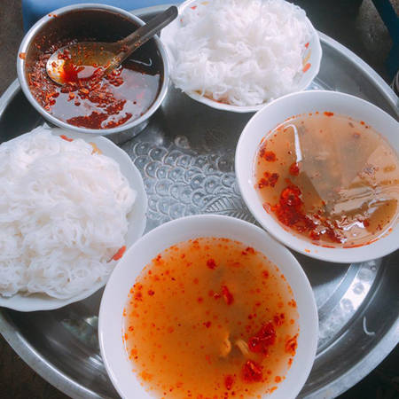 Bún ốc nguội Suất ăn gồm một đĩa bún để riêng và một bát nước dùng với những con ốc béo ngậy, giòn sần sật. Vị ốc tươi ngon quyện cùng vị chua cay, thơm mùi giấm của nước dùng và vị thanh mát của bún, rau sống thì cái nắng gắt mùa hè dường như được xua tan. Tuy nhiên, bún ốc nguội chỉ toàn là gánh hàng rong nên có không gian nhỏ hẹp và bạn thường phải chờ lâu khi đông khách. Một suất có giá 30.000 đồng. Các địa chỉ bán bún ốc nguội ngon là Ô Quan Chưởng, Bùi Thị Xuân, Tây Sơn…Ảnh: Triệu Phương Linh.