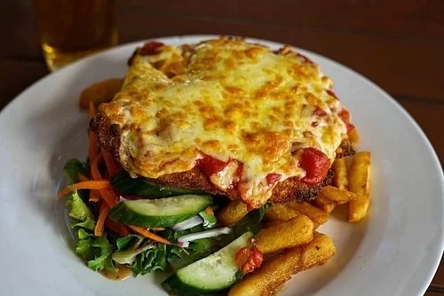 Gà parmigiana là món ăn Australia biểu tượng, gồm gà hầm sốt cà chua với phô mai và giăm bông prosciutto