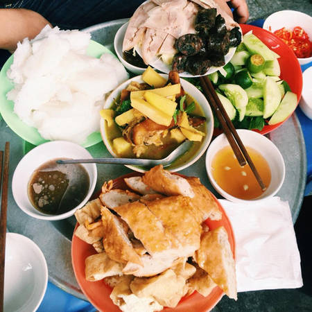 Đậu được rán sơ, chả xếp lớp, các bát nước chấm được xếp thành từng chồng cao là điều du khách ấn tượng khi tới quán bún đậu Cây Bàng, Đại La. Đậu làng Mơ chính hiệu nên miếng nào cũng mềm, thơm, béo ngậy. Mắm tôm, nước mắm cho thêm chút sa tế và được pha chế theo công thức riêng nên có hương vị đặc trưng. Một suất bún đậu đầy đặn bao gồm thịt và chả cốm có giá 30.000 đồng. Quán thường mở từ khoảng 11h đến 2h chiều. Ảnh: Ngọc Lê.