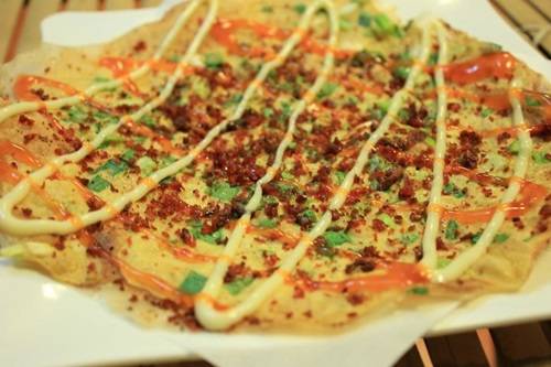 Đến từ xứ lạnh Đà Lạt nên bánh tráng nướng luôn đứng đầu danh sách những món ăn yêu thích của nhiều người Sài Gòn mỗi khi trời mưa. Vị cay của tương ớt pha lẫn cảm giác béo béo từ sốt mayonnaise trong chiếc bánh tráng trứng nướng nóng hổi sẽ làm dạ dày bạn thỏa mãn giữa những ngày trời trở gió. Ảnh: ameovat