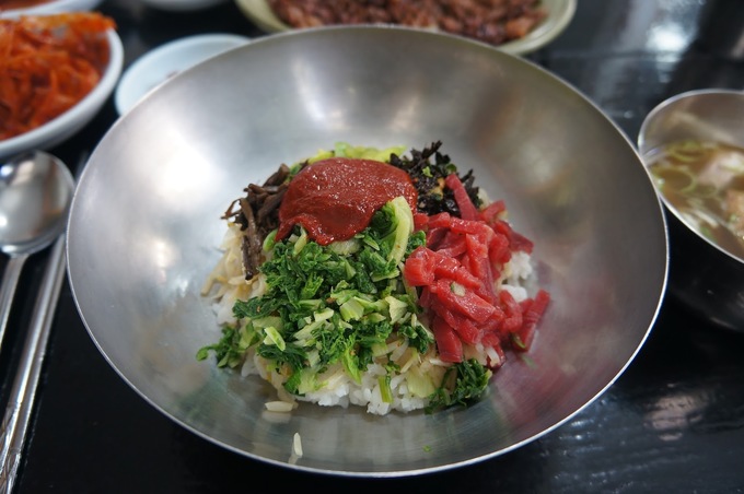 Cơm trộn yukhoe (thịt bò sống) gồm yukhoe, tảo biển khô, tương ớt cùng một vài nguyên liệu khác trộn chung với nhau cho vị vừa béo, vừa cay ăn khá lạ miệng. Cơm thường được làm nóng, đựng trong thố đá hoặc nhuôm dày để khi trộn lên, thịt bò có thể chín tái. Đây là một trong những món khá đặc trưng ở xứ củ sâm mà bạn khó có thể tìm thấy ở nơi nào khác.  Địa chỉ gợi ý: Cheonhwang, 3 Chokseok-ro207 beon-Gil, Jinju, Gyeongsangnam-do.