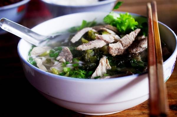 Ăn sáng bằng phở chua  Một món ngon dân dã khác của người dân Bắc Hà là phở chua. Khu ăn uống của chợ phiên này cũng có rất nhiều hàng quán bán phở chua cho khách chọn. Bát phở chua đầy đặn từ thịt, dưa chua, bánh phở tới rau thơm, ớt, muối ăn kèm. Một bát phở có giá 20.000 đồng.