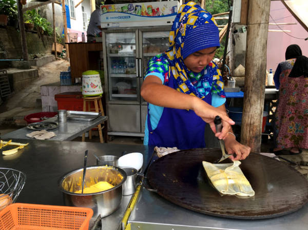 Một phụ nữ đạo Hồi làm món bánh Pancake chuối - Ảnh: Thủy OCG