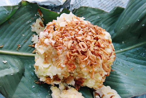 Khi bán xôi cho khách, người bán dùng đũa đơm xôi vào bát nhỏ, đổ lên lá sen, rồi nhanh tay thái nắm đậu thành từng lớp mỏng phủ lên trên mặt, bóc nhúm hành phi, rưới mỡ nước xung quanh. Ảnh: Phong Vinh
