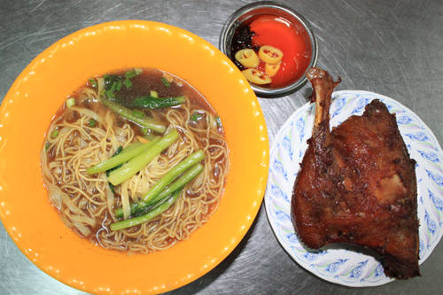 Chủ quán chia sẻ, để có được món ăn ngon, phần đùi và má đùi (gần một phần tư con vịt) được ướp thấm kỹ gia vị gia truyền, sau đó mang đi tiềm trong nước lèo có nhiều vị thuốc, cuối cùng miếng vịt được mang đi chiên rồi quay. Cách làm này khiến thịt vịt mềm trong khi phần da vừa giòn vừa thơm, ăn không bị ngán như cách tiềm thông thường. Ăn cùng vịt tiềm là mì vàng của người Hoa. Mì trứng trụng qua nước sôi cho vào tô cùng ít cọng cải luộc rồi chan nước tiềm vịt vào. Một phần ăn có giá từ 80.000 đồng. Ảnh: Huấn Phan.