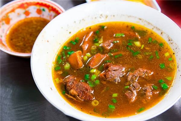 Khi gọi một tô hủ tiếu dê, bạn sẽ được phục vụ… đến 2 tô, 1 tô hủ tiếu và 1 tô thịt đầy dê. Phần nước lèo cực kì đậm đà, có màu bắt mắt với chút hành lá xanh, thịt dê vừa mềm vừa bổ dưỡng… tóm lại là không thể chối từ! (Ảnh: Internet)