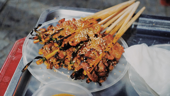Thịt được kẹp đũa nướng than hồng cho bánh ướt thịt nướng Hội An