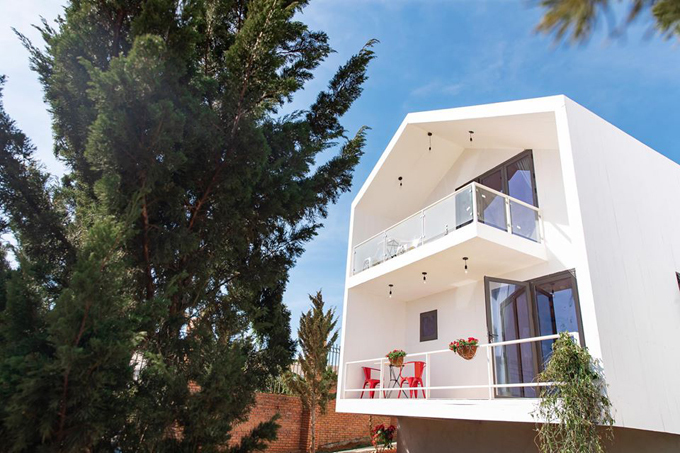 Các căn villa resort Lý Nhã Kỳ được thiết kế phong cách tối giản, chọn màu trắng và trang trí đơn sắc, xen lẫn cây thông xanh rì.