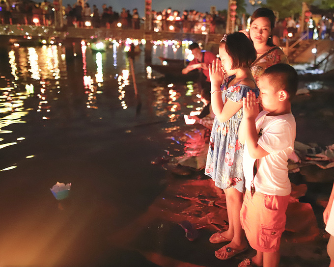 Du khách thả hoa đăng trên bờ sông Hoài