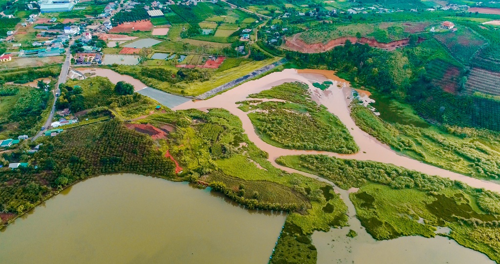 Một góc xã Tà Nung, thị trấn Nam Ban trở nên tuyệt đẹp dưới ống kính flycam. Bên dưới là trang trại cà phê nổi tiếng, hồ đập Cam Ly, cánh đồng hoa, xa xa là những mái nhà trập trùng và đèo Tà Nung uốn lượn. Những gam màu xanh, đỏ, vàng đan xen, tạo nên bức tranh vùng ngoại ô thanh bình, mộc mạc.