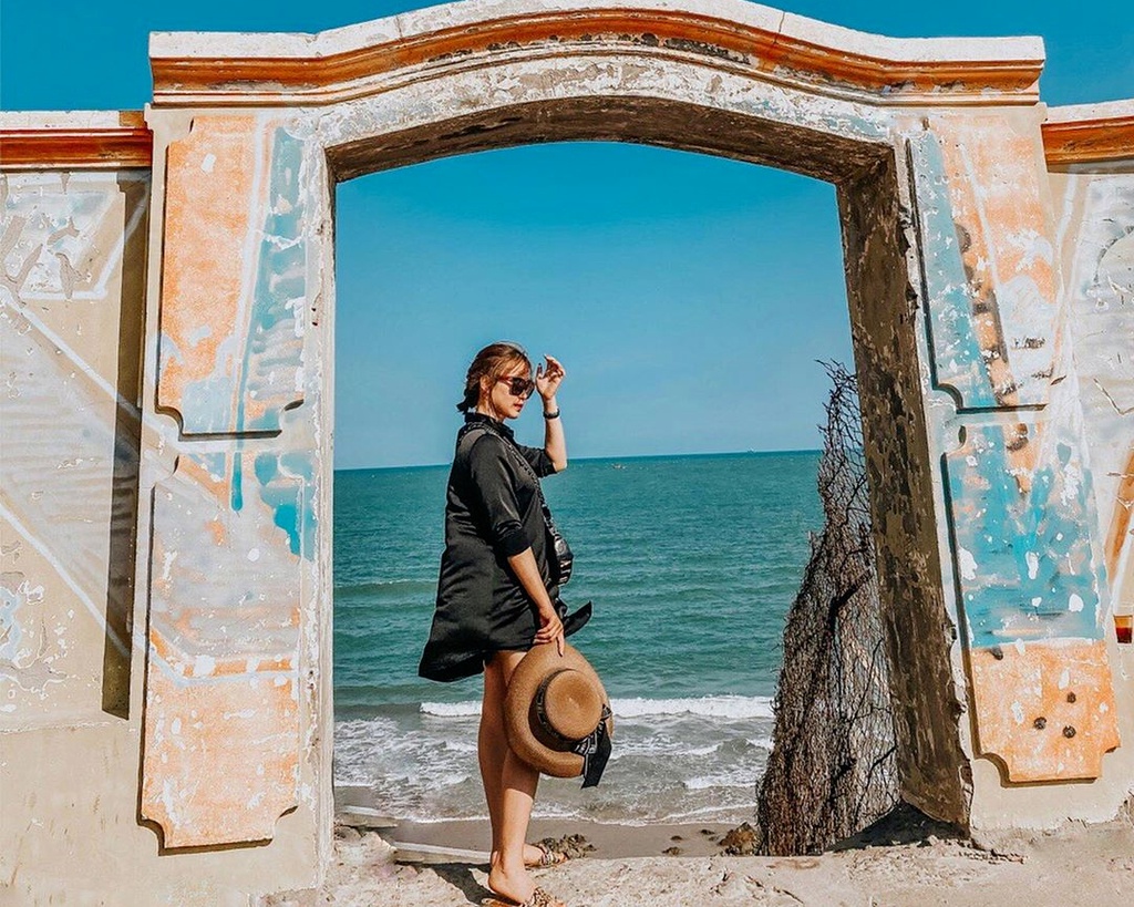 Khi thấy công trình màu vàng, nằm nổi bật trên nền trời biển xanh ngắt, là lúc bạn đã "chạm tay" tới cổng trời. Chiếc cổng không lớn và cũng chẳng có kiến trúc quá đặc biệt. Tuy nhiên, khi bước qua cánh cổng này, bạn sẽ thu vào tầm mắt bức tranh thiên nhiên đẹp tựa tranh vẽ. Đó là một vùng biển bao la, lộng gió, lấp lánh ánh nắng, phía xa là thành phố Vũng Tàu nhộn nhịp. Ảnh: Ngochuyenn158.