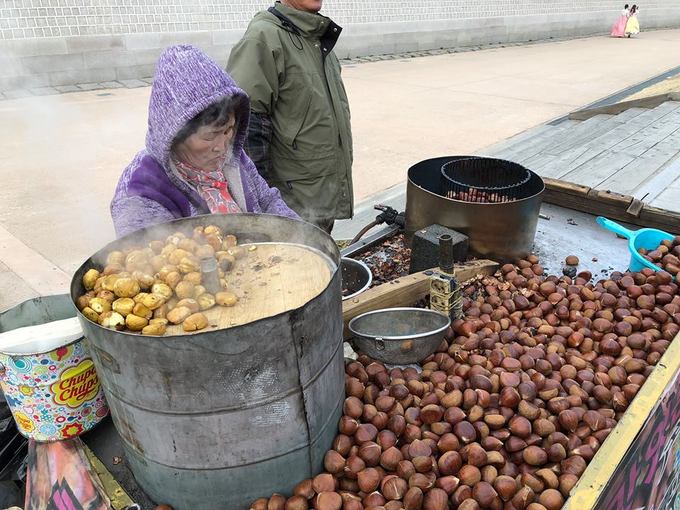 Nếu đi ngắm hoa anh đào mùa này thì hạt dẻ rang thơm lừng của các cụ già bên vệ đường là món “lương khô” không thể thiếu cho những buổi đi dạo của bạn. Một bịch nhỏ khoảng 5.000 won (khoảng 100.000 đồng), hạt to, tươi, thơm bùi nóng hổi sẽ khiến bạn thích thú.