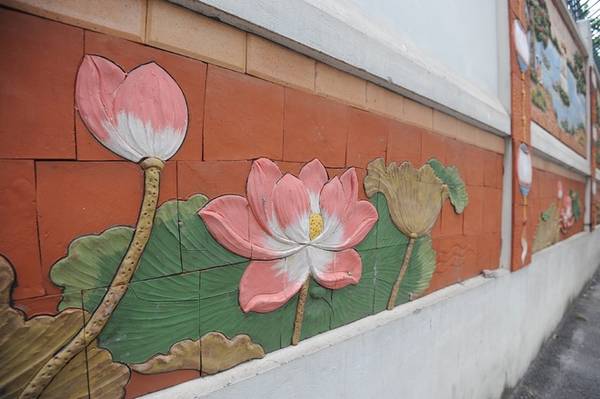 Họa tiết hoa sen gốm sứ trang trí ở phần dưới bức tường.