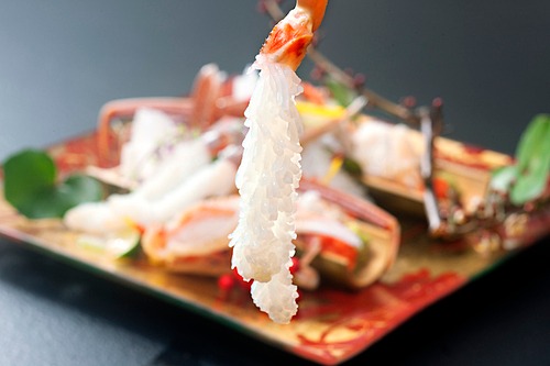 Đầu bếp làm sashimi cua tuyết Nhật Bản bằng cách lột bỏ lớp vỏ chân rồi ngâm phần thịt vào nước đá 10 phút. Thịt cua xòe ra trông như chùm lá thông. Ảnh: Guide Michelin.