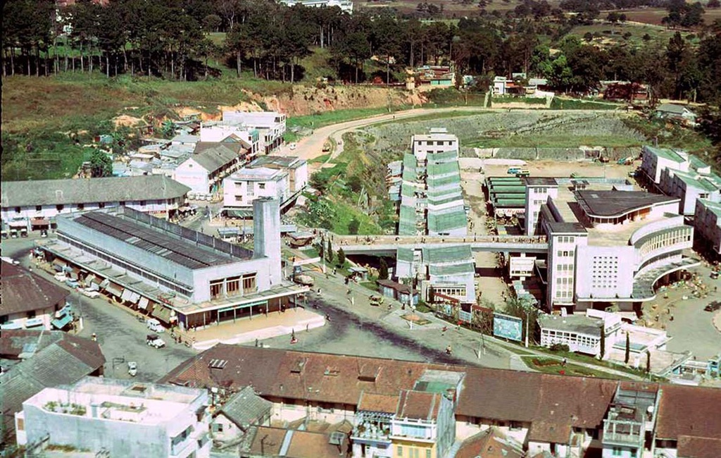 Được xây dựng từ năm 1929, chợ Đà Lạt nằm trong khu trung tâm Hòa Bình, là khu vực giao thương nhộn nhịp, sầm uất của địa phương. Cây cầu đi bộ, điểm check-in nổi tiếng của giới trẻ, nằm trong hạng mục được xây dựng thêm vào năm 1958. Ảnh: Bill Robie.