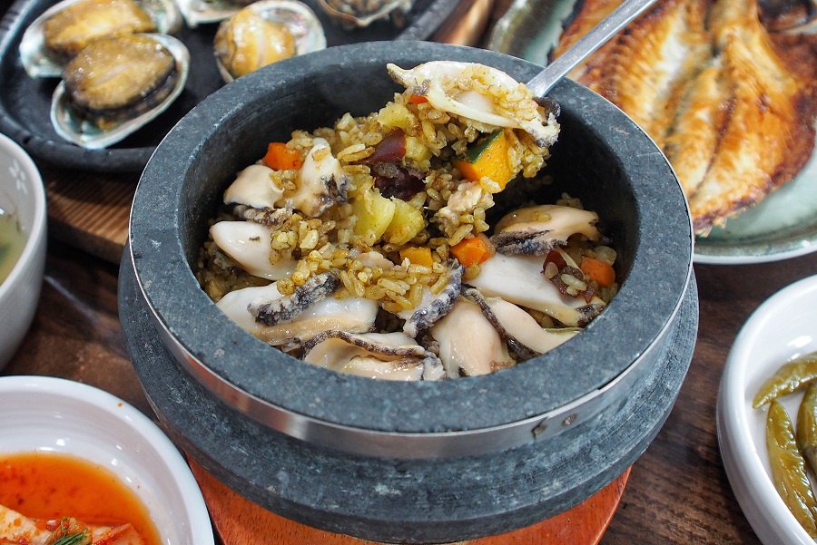 Ngoài ra, bạn còn có thể ăn thử món cơm rang bào ngư. Cơm được nấu cùng bí đỏ tạo ra màu vàng bắt mắt và bày trong thố đá nóng, với bào ngư cắt lát phía trên. Thực khách cần rưới một chút nước vào bát để hơi nước bốc lên khiến cơm mềm, béo ngậy và ngon hơn. Ảnh: Danielfooddiary.