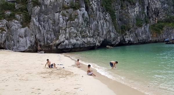 Trẻ em nô đùa nghịch cát và sóng ở Đảo Mắt Rồng