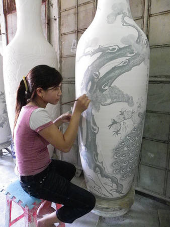 Nghệ nhân vẽ họa tiết thủ công lên bình gốm tại Bát Tràng