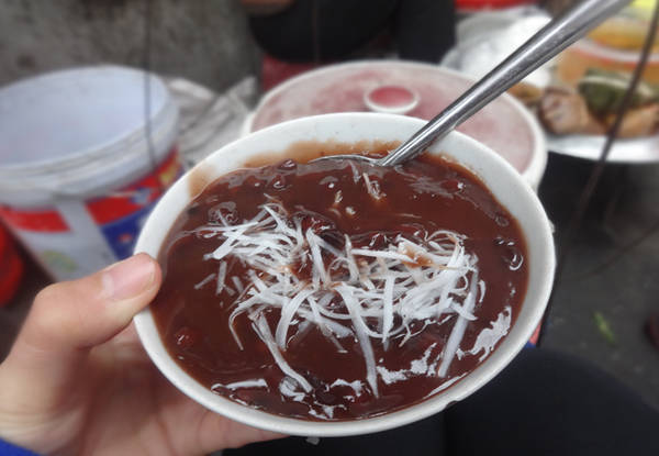 Ngoài bánh đúc nóng, cô Hạnh bán thêm chè nóng và bánh nếp. Bát chè đỗ đen nóng hổi, không quá ngọt ăn với dừa tươi thái sợi; bánh nếp to ngon, đầy đặn… đều được bán với giá 5.000 đồng. Ảnh: Tuyết Mai.
