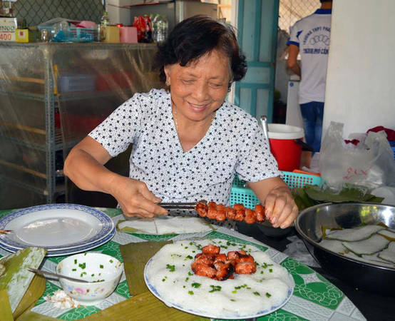 Nghệ nhân Châu Kim Thuận đang xếp bánh hỏi phục vụ du khách