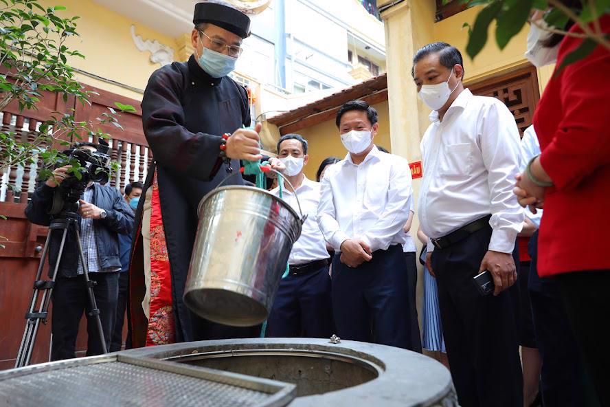 Lấy nước giếng để làm lễ ở đền Bạch Mã. Ảnh: kinhtedothi.
