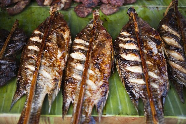 Lào không có biển nên thường sử dụng cá sông để nướng, gọi là Ping Pa. Cá sông thịt ngọt hơn, ướp lá chanh, rau mùi... nướng đến vàng da dậy mùi thơm hấp dẫn thực khách - Ảnh: Tim Gerard Baker