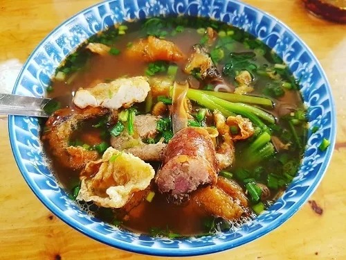Bát bún cá cay đầy đủ các loại nhân như cá rán, bề bề, tôm và dồi tại quán ăn Hà Nội Huế